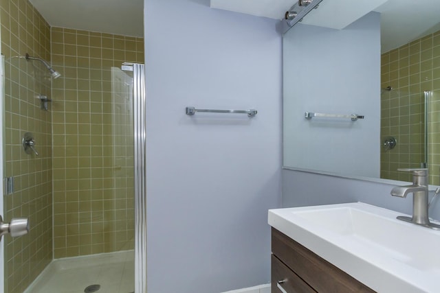 bathroom featuring a tile shower and vanity