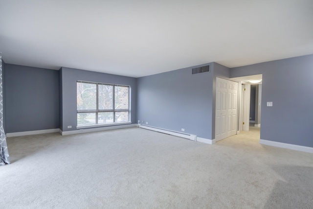 empty room featuring light carpet and a baseboard heating unit