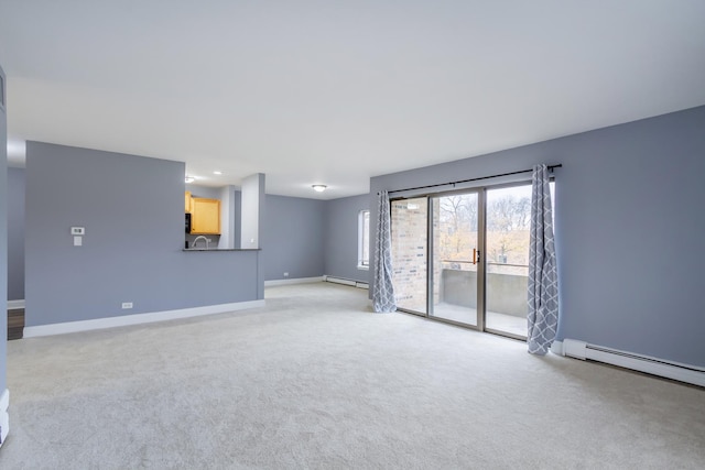 carpeted empty room featuring a baseboard heating unit