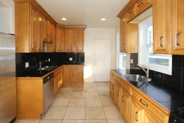 kitchen with backsplash, sink, light tile patterned flooring, and stainless steel appliances