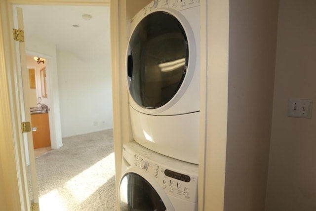 laundry area featuring carpet flooring and stacked washer / drying machine