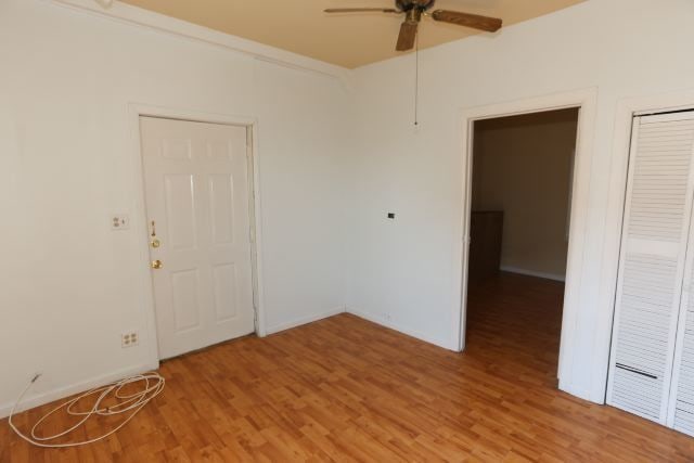 spare room with ceiling fan and wood-type flooring