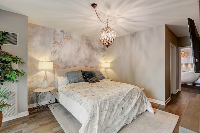 bedroom featuring wood-type flooring and an inviting chandelier