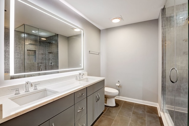 bathroom featuring tile patterned flooring, vanity, toilet, and an enclosed shower