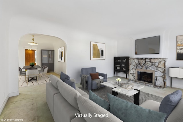 living room featuring light colored carpet and a stone fireplace