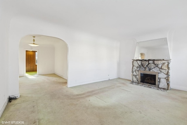 unfurnished living room featuring light colored carpet and a fireplace