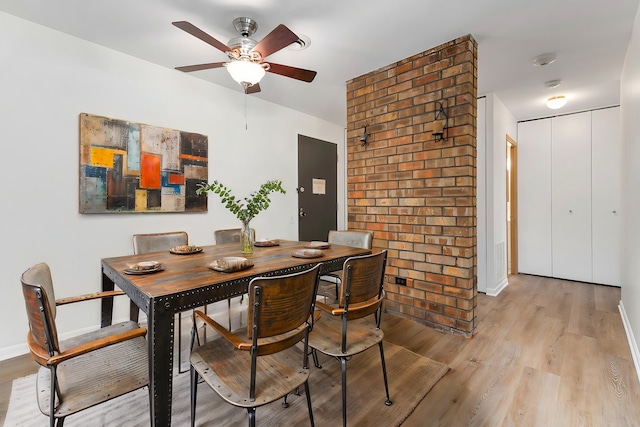 dining space with ceiling fan and light wood-type flooring