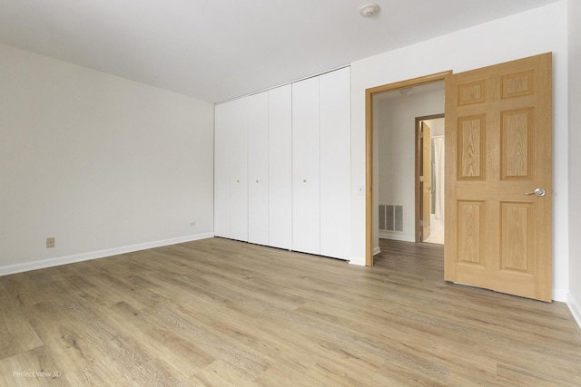 unfurnished bedroom with a closet and light hardwood / wood-style floors