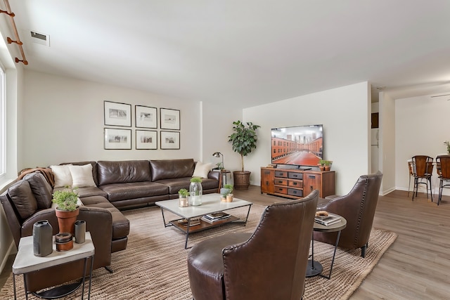 living room featuring ceiling fan and light hardwood / wood-style floors