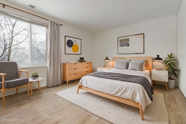 bedroom with light wood-type flooring and multiple windows