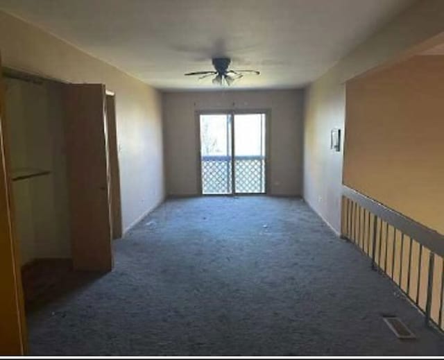 carpeted spare room with ceiling fan