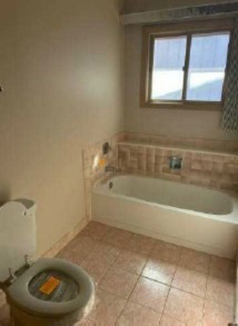 bathroom with tile patterned flooring and a tub