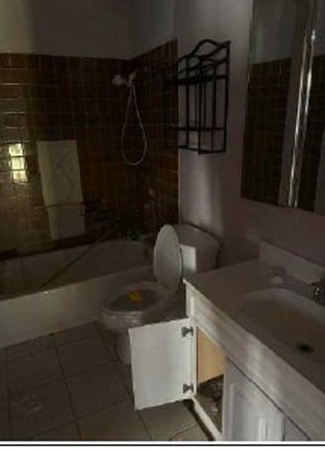 full bathroom with tile patterned floors, vanity,  shower combination, and toilet