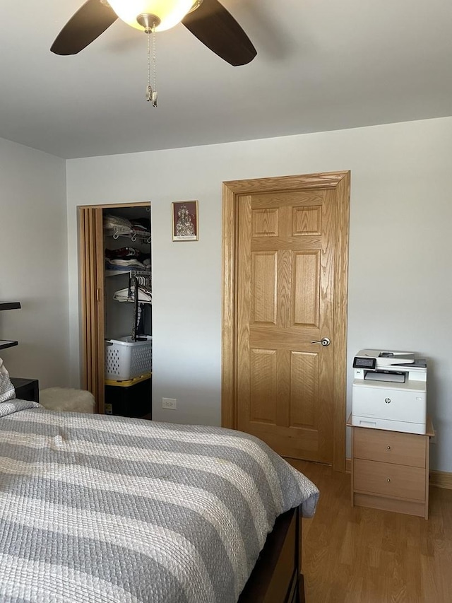 bedroom featuring light wood-type flooring, ceiling fan, and a closet