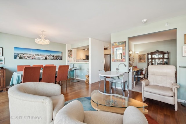 living room featuring an inviting chandelier, baseboards, and dark wood-style flooring