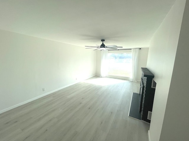 unfurnished living room with ceiling fan and light wood-type flooring