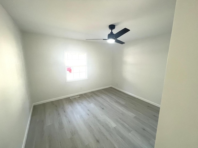 empty room with ceiling fan and light wood-type flooring