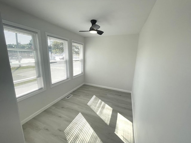 unfurnished sunroom with ceiling fan and plenty of natural light