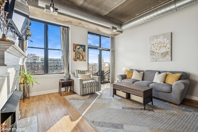 living room featuring a healthy amount of sunlight, a city view, and hardwood / wood-style flooring