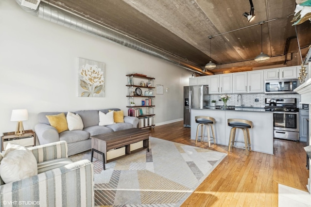 living area featuring light wood-style floors, visible vents, and baseboards