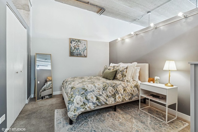 carpeted bedroom with a closet and baseboards