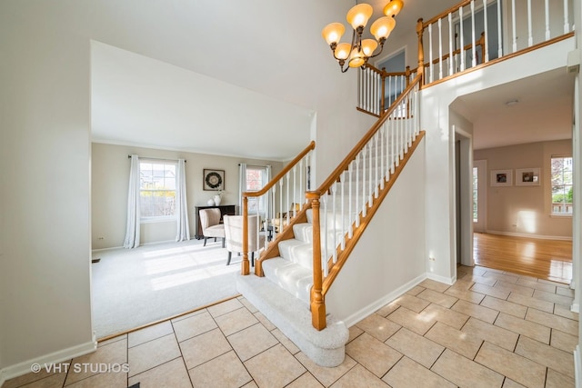 staircase with tile patterned floors and a notable chandelier