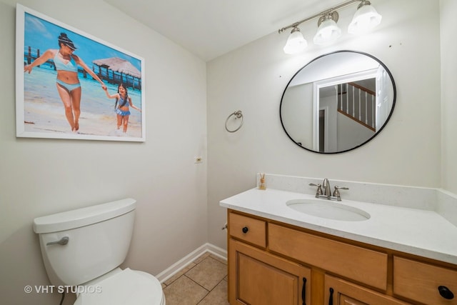 bathroom with tile patterned flooring, vanity, and toilet