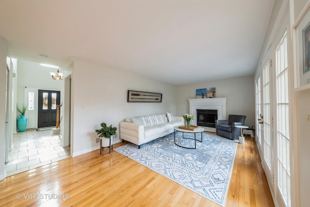 living room with hardwood / wood-style floors, a chandelier, and french doors