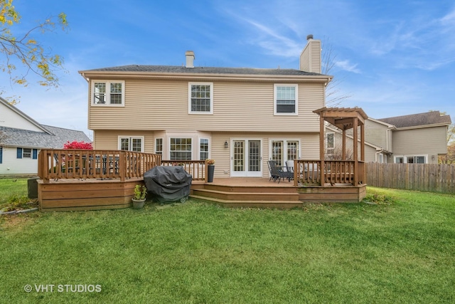 back of property with a lawn, a pergola, and a wooden deck