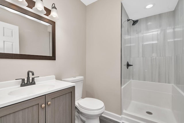 bathroom with toilet, vanity, and walk in shower