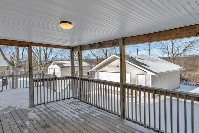 wooden deck featuring a garage and an outbuilding