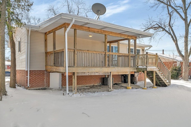 snow covered house with a wooden deck