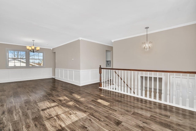 spare room with dark hardwood / wood-style flooring, crown molding, and a chandelier