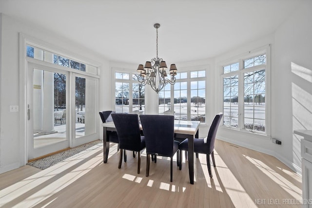 dining space featuring an inviting chandelier and light hardwood / wood-style flooring