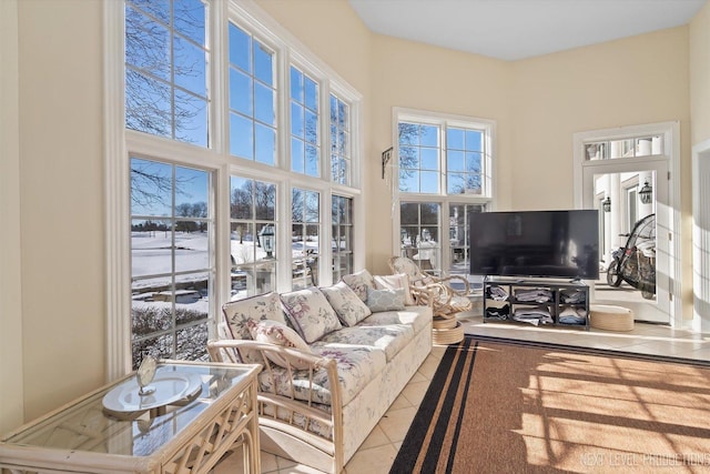 living room with a towering ceiling and light tile patterned floors