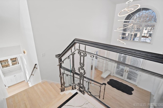 stairs featuring an inviting chandelier and hardwood / wood-style flooring