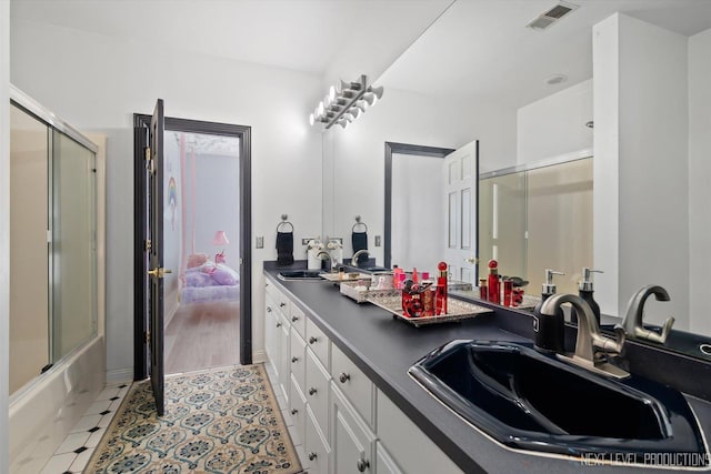 bathroom featuring bath / shower combo with glass door, tile patterned floors, and vanity