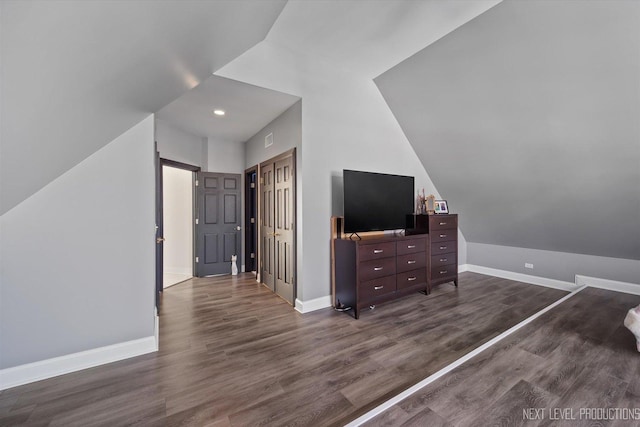 bedroom with lofted ceiling, a closet, and dark wood-type flooring