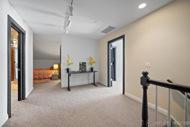 hallway with rail lighting and light carpet