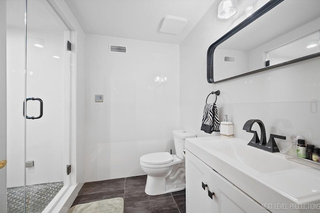 bathroom featuring a shower with door, vanity, and toilet