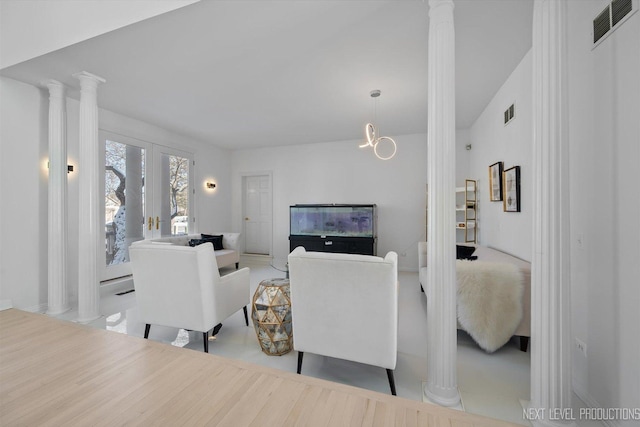 living room featuring french doors and an inviting chandelier