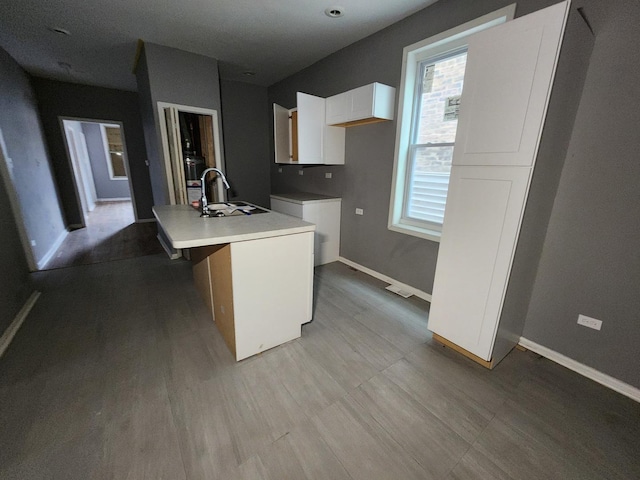 kitchen with white cabinetry, a kitchen island with sink, plenty of natural light, and sink