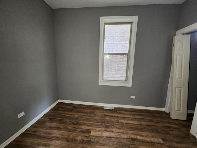 spare room with dark wood-type flooring