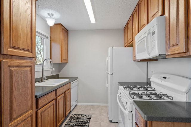 kitchen featuring a textured ceiling, sink, light tile patterned floors, and white appliances