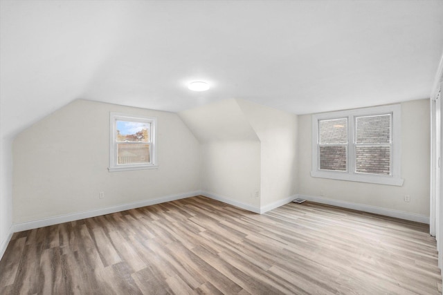 bonus room with light hardwood / wood-style floors and lofted ceiling