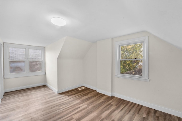 additional living space featuring light hardwood / wood-style floors and lofted ceiling