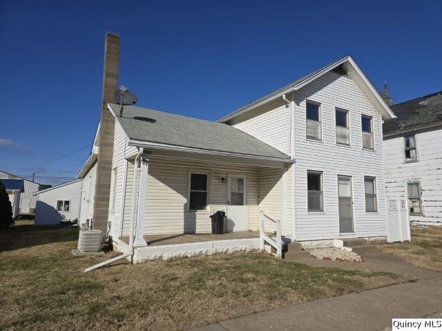 view of front of home featuring a porch, a front yard, and cooling unit