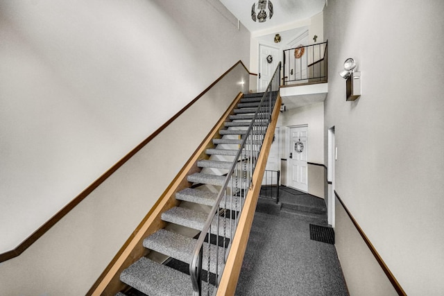 staircase featuring carpet flooring and a towering ceiling