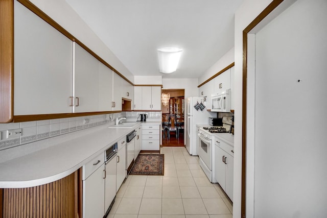 kitchen with white appliances, white cabinets, sink, decorative backsplash, and light tile patterned floors