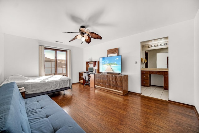 bedroom featuring hardwood / wood-style flooring, ceiling fan, and connected bathroom